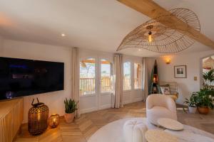 ラカノーにあるLes Villas de Julie au Domaine des Musesのテレビとテーブルと椅子のあるリビングルーム