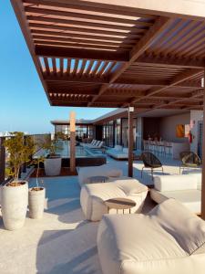 an outdoor patio with white couches and tables at IorubaStudio in Salvador +16 photos