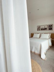 a bedroom with a white bed and a white curtain at IorubaStudio in Salvador +16 photos