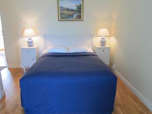 una camera da letto con un letto blu con due comodini di Tössestugan a Tösse