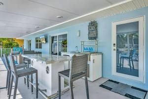 a kitchen with blue walls and chairs and a counter at Sunny Bank in Marathon