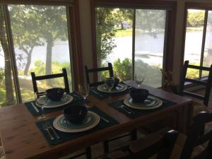 a dining room table with a view of the water at Waterfront house in Falmouth
