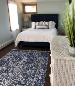 a bedroom with a bed and a blue and white rug at Waterfront house in Falmouth
