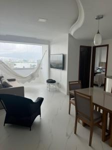 un soggiorno con tavolo, sedie e un'amaca di Apartamento Novo Renascença Vista Lagoa a São Luís