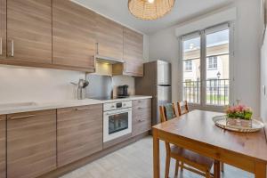 a kitchen with wooden cabinets and a table and a dining room at Accommodation closest to Disneyland in Serris