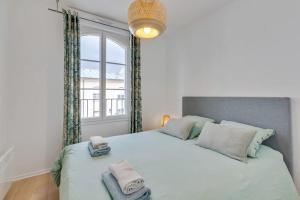 a bedroom with a large bed with two towels on it at Accommodation closest to Disneyland in Serris