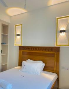 a bedroom with a white bed with two pictures on the wall at Habibi Homes in Mombasa