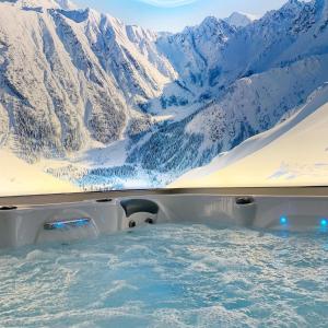 a bath tub with a view of a snow covered mountain at Courchevel Room avec jacuzzi et sauna privatif in Annemasse