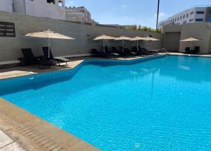 ein großer blauer Swimmingpool mit Stühlen und Sonnenschirmen in der Unterkunft Prestige stay with swimming pool in Agadir + 15 Fotos