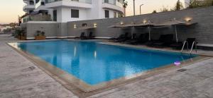 ein großes Schwimmbad mit Stühlen und einem Gebäude in der Unterkunft Prestige stay with swimming pool in Agadir