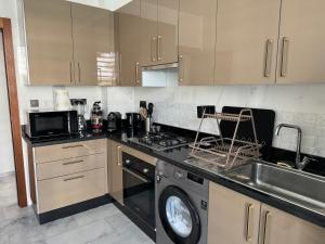 eine Küche mit Waschmaschine und Spüle in der Unterkunft Prestige stay with swimming pool in Agadir