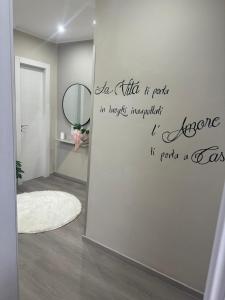 une pièce avec un miroir et un mur avec une citation dans l'établissement Suite Dream, à Reggio de Calabre
