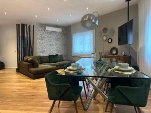 a living room with a glass table and green chairs at Casa da Villa in Vila Nova de Foz Coa
