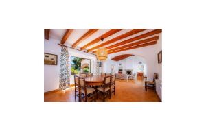 a dining room and living room with a table and chairs at Es Calo De N'aladern in Capdepera