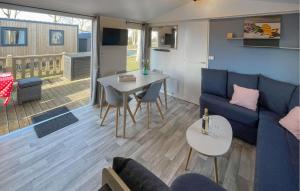 Una sala de estar con un sofá azul y una mesa. en Chalet Lauwersoog, en Lauwersoog
