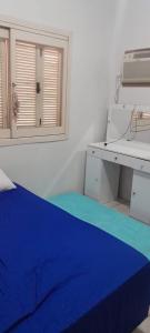 een kamer met een naaimachine en een blauwe deken bij Casa Denis in Pântano Grande