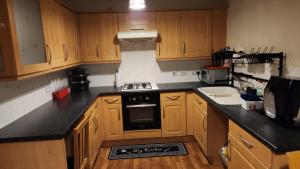 a kitchen with wooden cabinets and a stove top oven at Mekees Luxury Apartment in Tipton