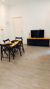 Cette chambre dispose d'une télévision à écran plat ainsi que de deux tables et chaises. dans l'établissement Apartamentos Trastamara, à Séville