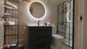 un bagno con lavandino, WC e specchio di Casa Luz del Mar a Los Realejos Altre 28 foto