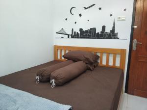 a bed with a brown pillow on top of it at Syariah Ampana Guest House in Dondo
