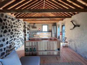 a living room with wooden furniture and a stone wall at Casa 3 Picos 2 in São Roque do Pico