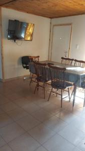 Un comedor con mesa y sillas y un televisor. en Casa de Playa - 6 Personas, en Balneario Pehuén-Có