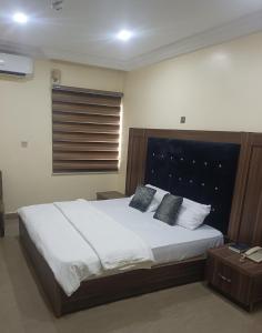 a bedroom with a large white bed with two pillows at Angels Court Hotel and Suites in Sagwari