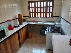 eine Küche mit Herd und Spüle in der Unterkunft Casa guarirobas in Alto Paraíso de Goiás