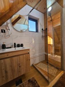 a bathroom with a shower and a sink and a mirror at Villas Sunny Hill in Žabljak +69 photos