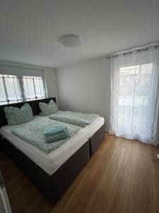 a bedroom with a bed with a wooden floor at Ferienwohnung Sonnenblick in Hilzingen