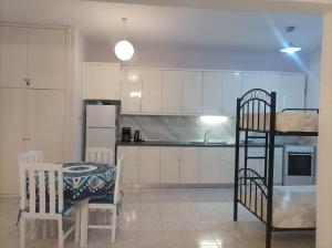 a kitchen with white cabinets and a table and chairs at Beachfront Eva's House in Karianí