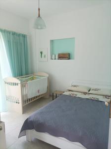 a bedroom with two cribs and a bed with a blue blanket at Beachfront Eva's House in Karianí