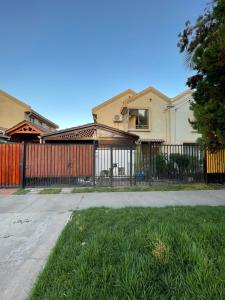 a fence in front of a house with a yard at Hostal Brisa Serena in Santiago