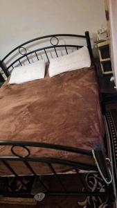 a metal bed with two white pillows on it at rafat house in Amman