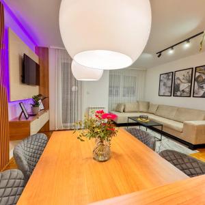 a living room with a table with a vase of flowers at PARK INN in Lukavica