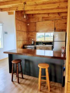 a kitchen with a large counter and two stools at Cabaña vista al mar in Castro