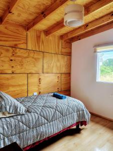 a bedroom with a bed and a wooden ceiling at Cabaña vista al mar in Castro