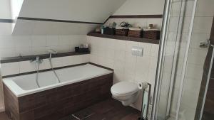 a bathroom with a tub and a toilet and a shower at Lisas Unterkunft in Waldburg