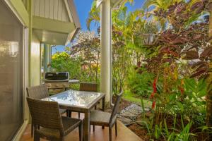 a patio with a table and chairs and a grill at Keiki Honu Kauai Princeville 2BR2BA King+Queen bed in Princeville