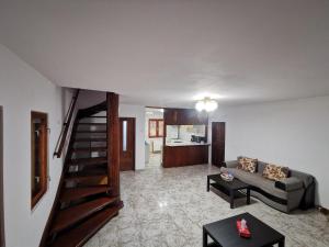 a living room with a couch and a spiral staircase at Eva's Garden in Breaza