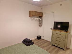 a bedroom with a bed and a tv on a dresser at Highbanks in Newhaven