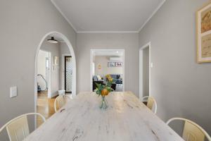 a dining room with a table with a vase of oranges on it at Charming 3 Bedroom Family Home Pet Friendly in Hamilton