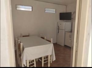 eine Küche mit einem weißen Tisch und einem Kühlschrank in der Unterkunft Altos del Seminario in Paraná