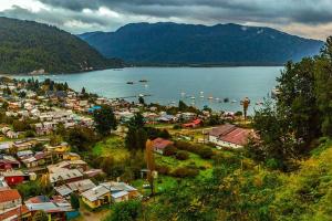 a town next to a body of water with boats at Baguales Patagonia in Puerto Cisnes