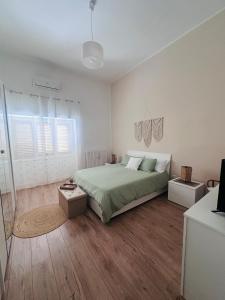 una camera bianca con letto e pavimenti in legno di La Rosa di Candy a Brindisi Altre 25 foto