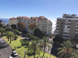 ein Blick auf eine Stadt mit Palmen und Gebäuden in der Unterkunft Forum Ocean View Apartment in Funchal