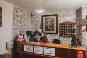 a woman sitting at a counter in a barber shop at Intitambo Hotel in Ollantaytambo