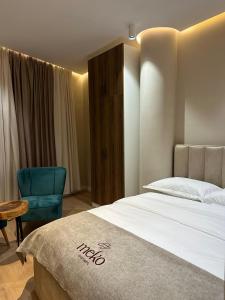 a bedroom with a bed and a blue chair at Meko Apartments in Tirana