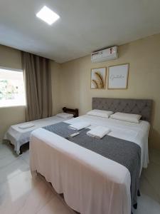 ein Schlafzimmer mit zwei Betten mit weißer Bettwäsche in der Unterkunft casa ampla com PISCINA e área verde em São José ao lado de Maragogi in São José da Coroa Grande
