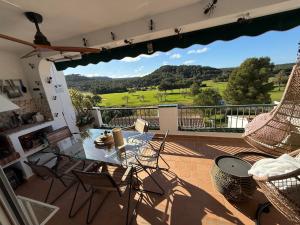 a patio with a glass table and chairs on a balcony at FLAT Surrounded by Nature WIFI & Pool & beach Nearby in Son Parc